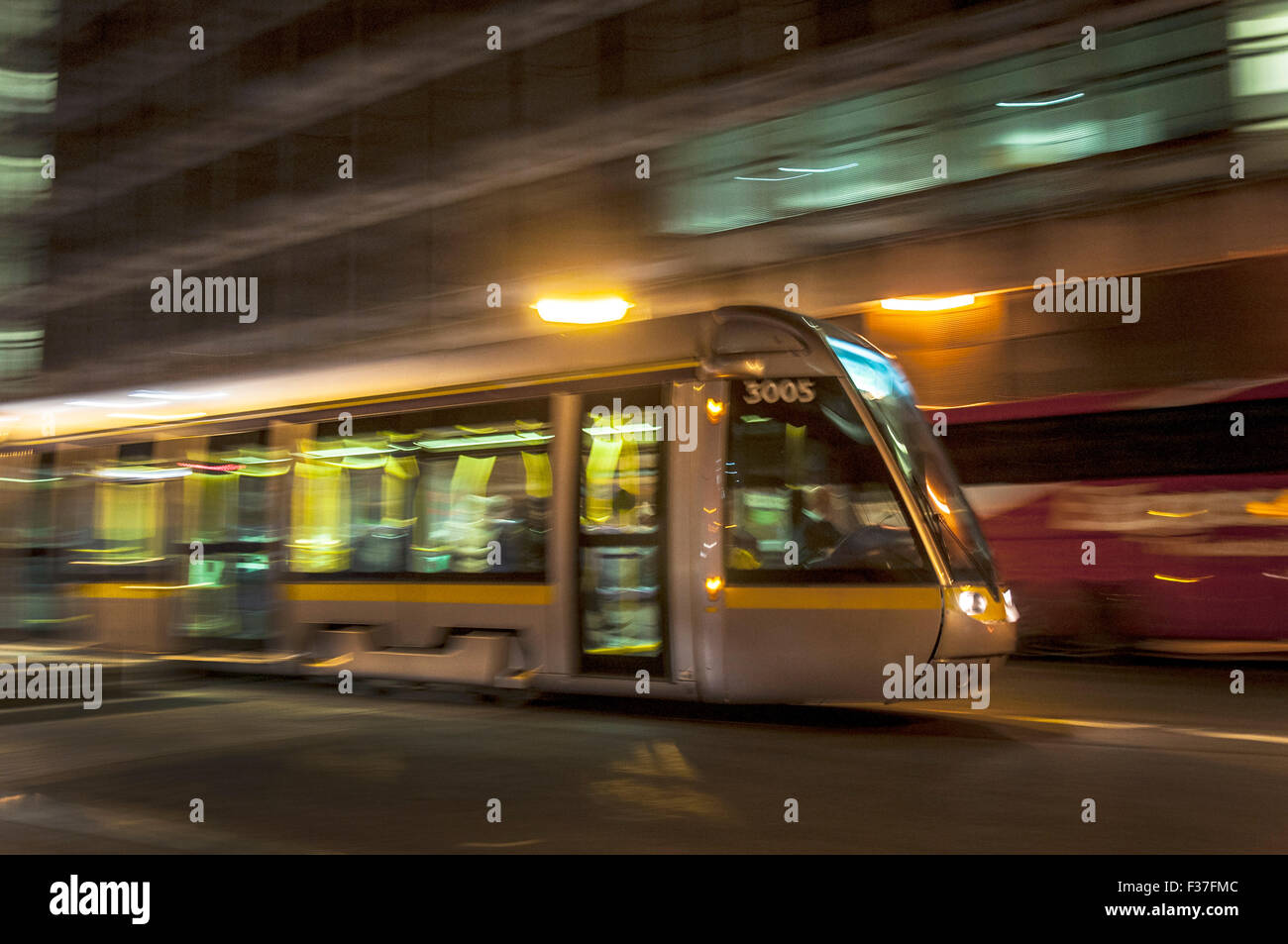 Tempo di notte a Dublino, Irlanda. Un tram Luas con velocità le sfocature Foto Stock