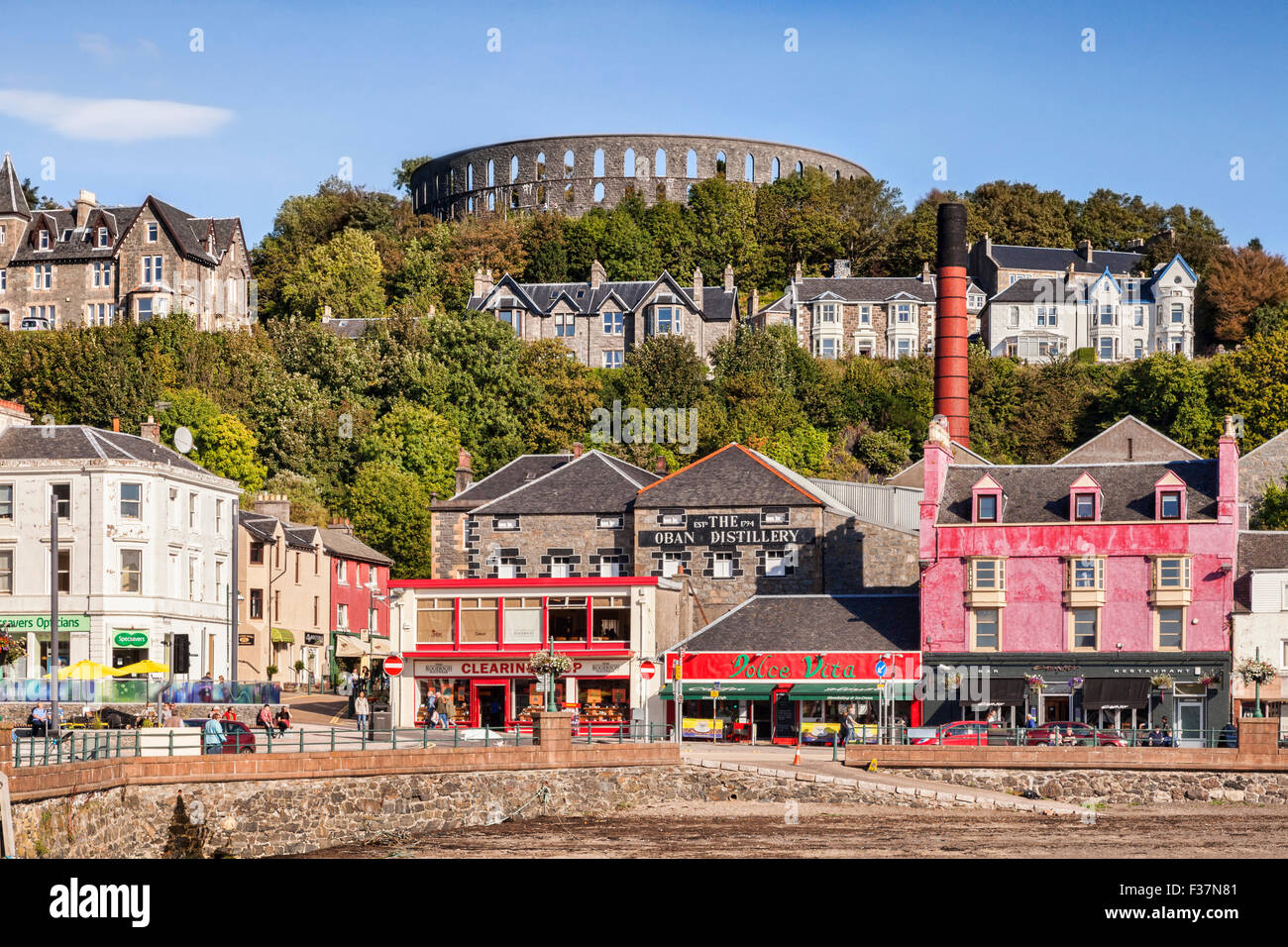 Waterfront a Oban, con negozi, Oban Distillery e McCaig's Tower, Argyll and Bute, Scotland, Regno Unito. Foto Stock