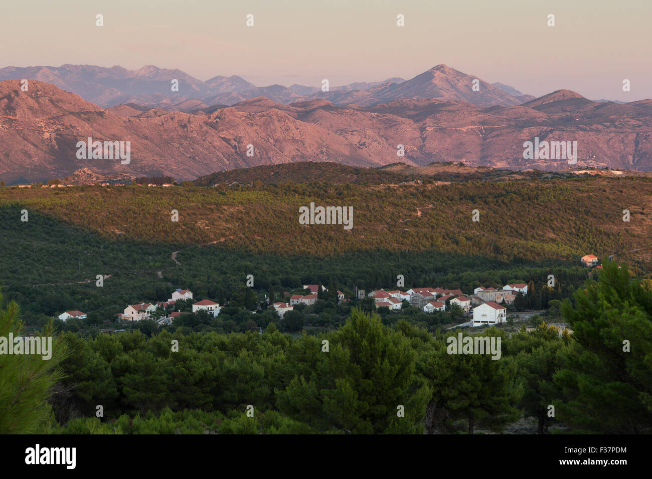 Vista di un piccolo villaggio e Alpi Dinariche in Bosnia e Erzegovina dal monte Srd a Dubrovnik, Croazia al tramonto. Foto Stock