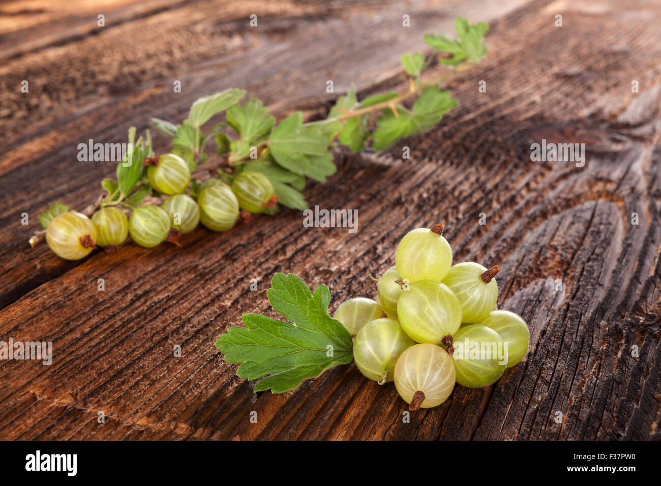 Ribes verde con foglie verdi su legno tabella vintage. Una sana frutta estiva di mangiare. Foto Stock