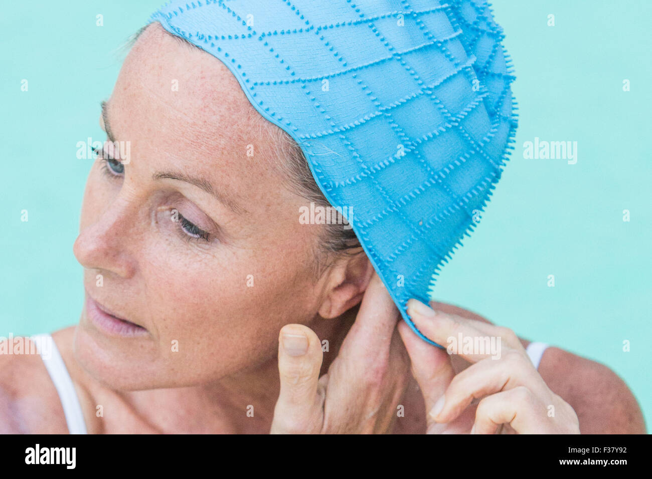 La donna in un pool di indossare una cuffia. Foto Stock