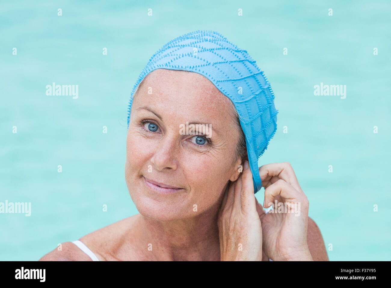 La donna in un pool di indossare una cuffia. Foto Stock