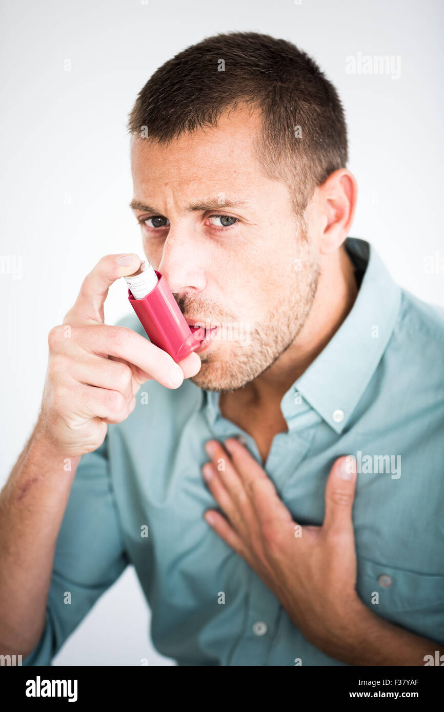 Uomo che utilizza un inalatore durante un attacco d' asma. Foto Stock