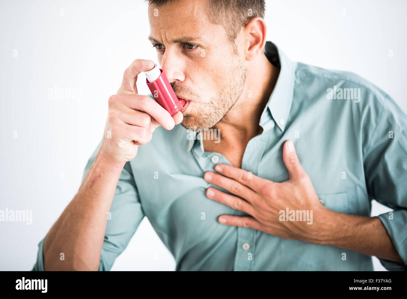 Uomo che utilizza un inalatore durante un attacco d' asma. Foto Stock