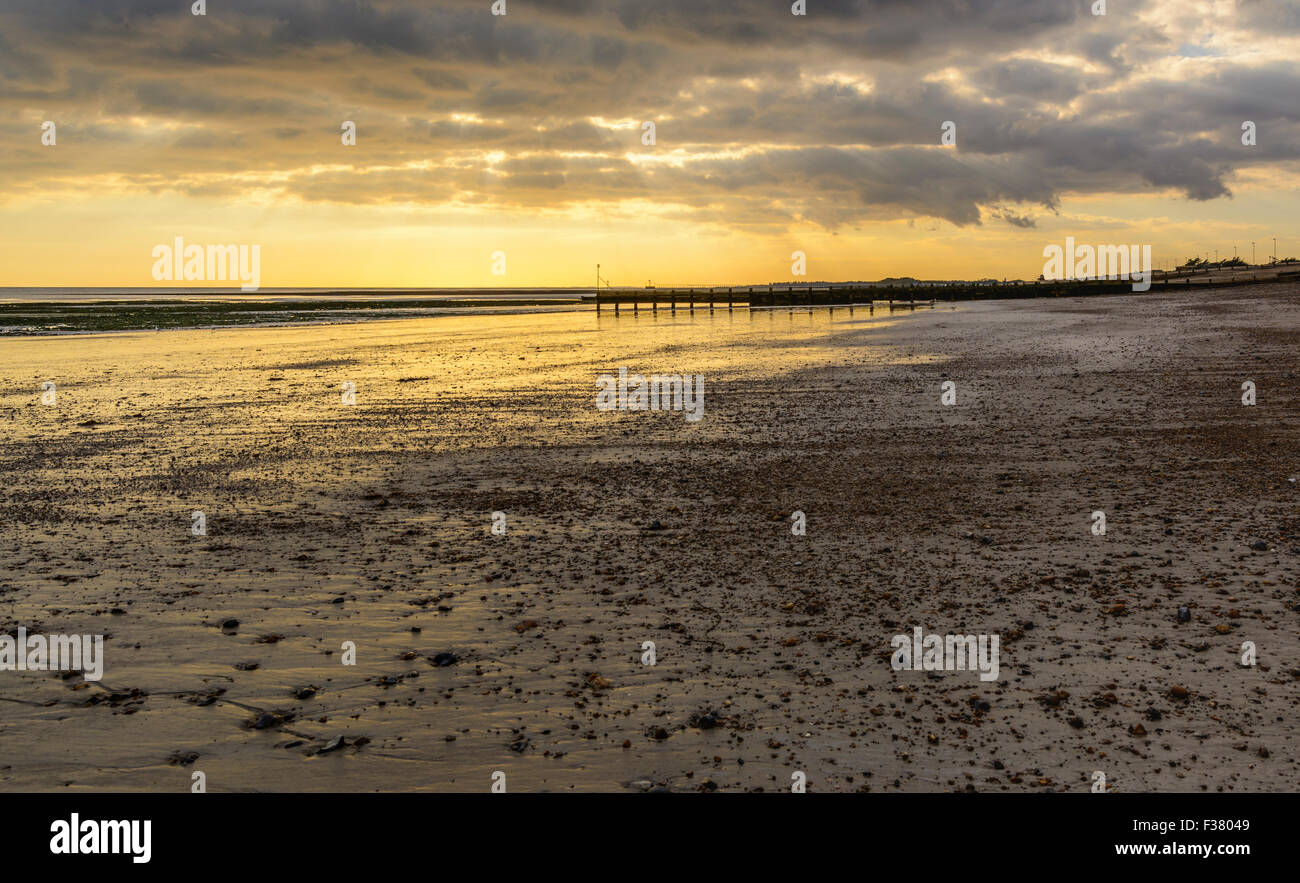 Spiaggia deserta a bassa marea in prima serata dopo che il sole ha impostato.in Inghilterra, Regno Unito. Foto Stock