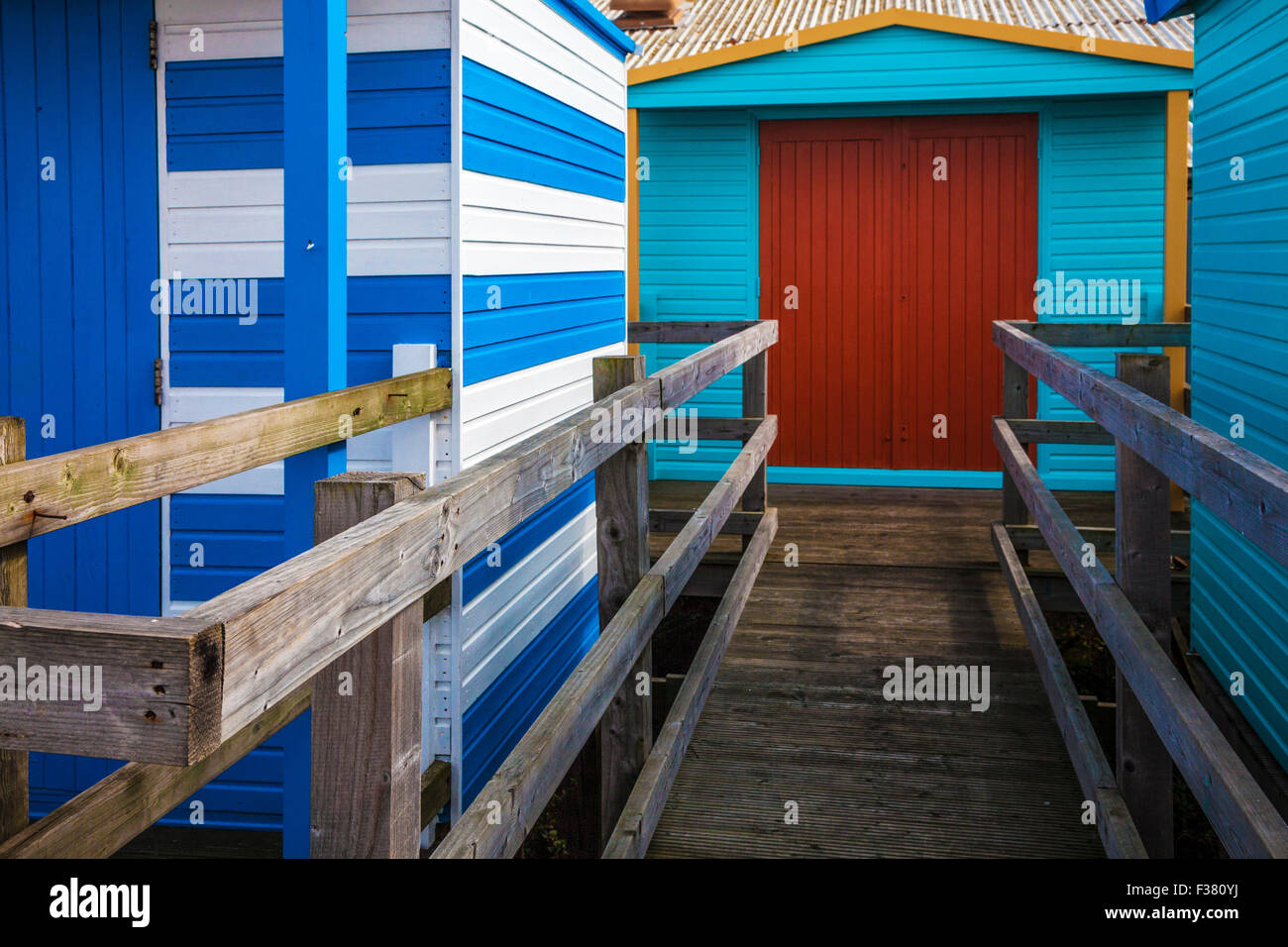 In legno colorato capanne sulla spiaggia in Kentish resort costiero di Whitstable. Foto Stock