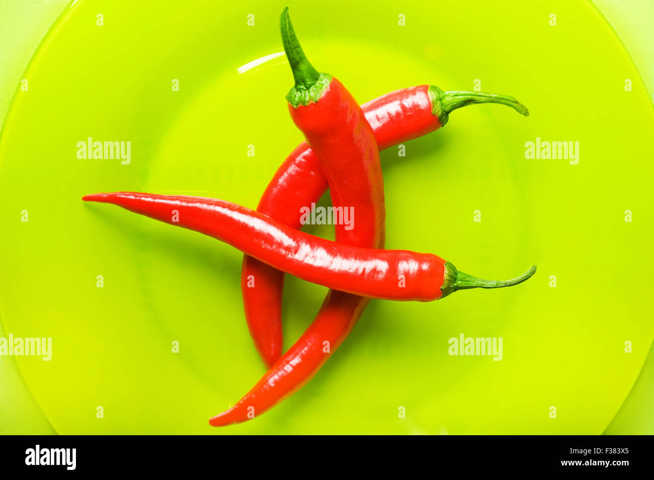 Rosso peperoncini jalapeno nella piastra verde Foto Stock