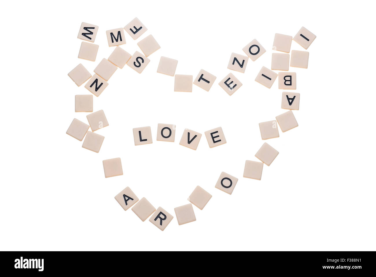 Piccola selvaggina di piastrelle con lettere su di essi disposti in un cuore che circonda la parola 'amore' isolato su uno sfondo bianco. Foto Stock