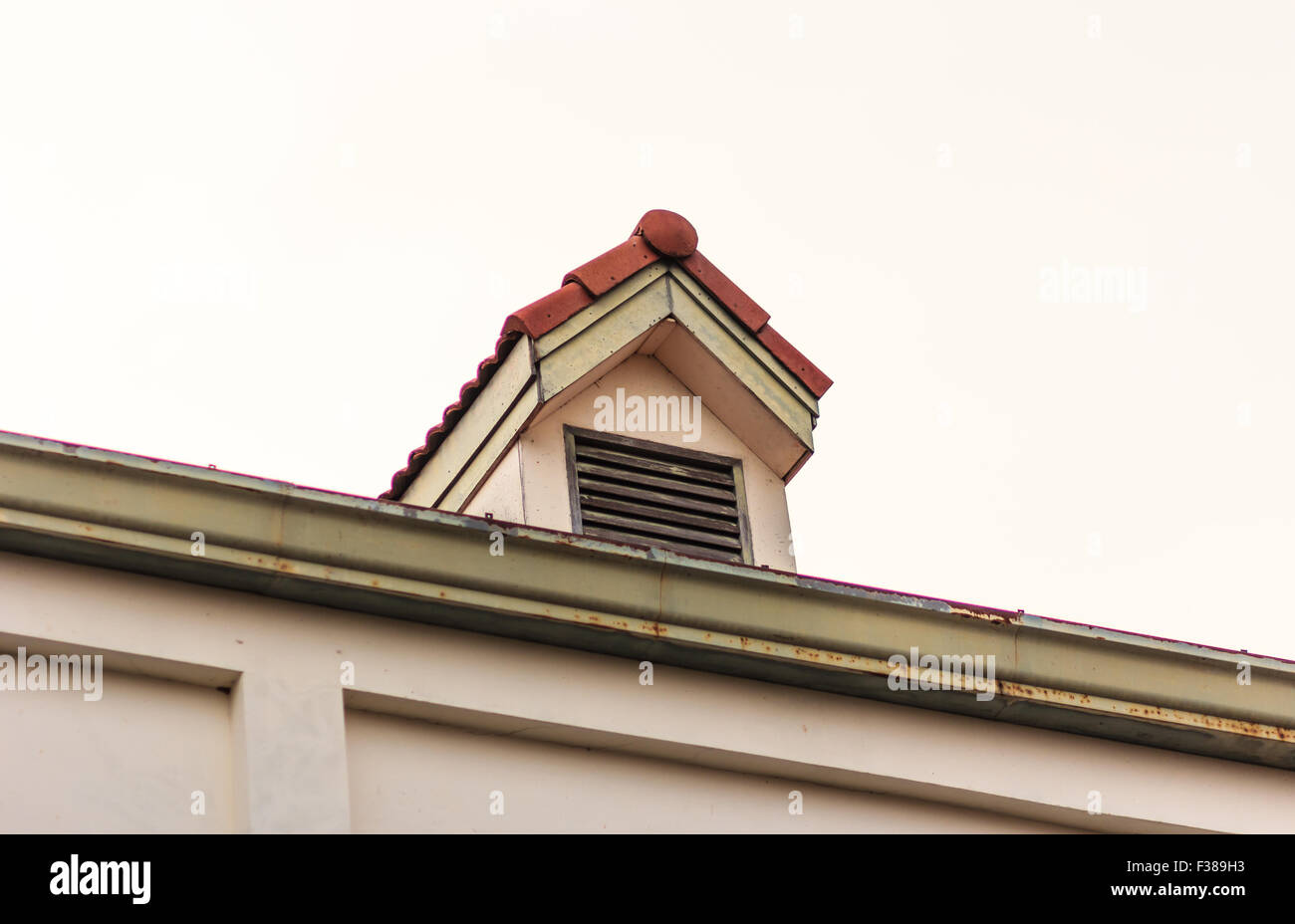 Camini sul tetto di tegole rosse con cielo blu e nuvole. Foto Stock