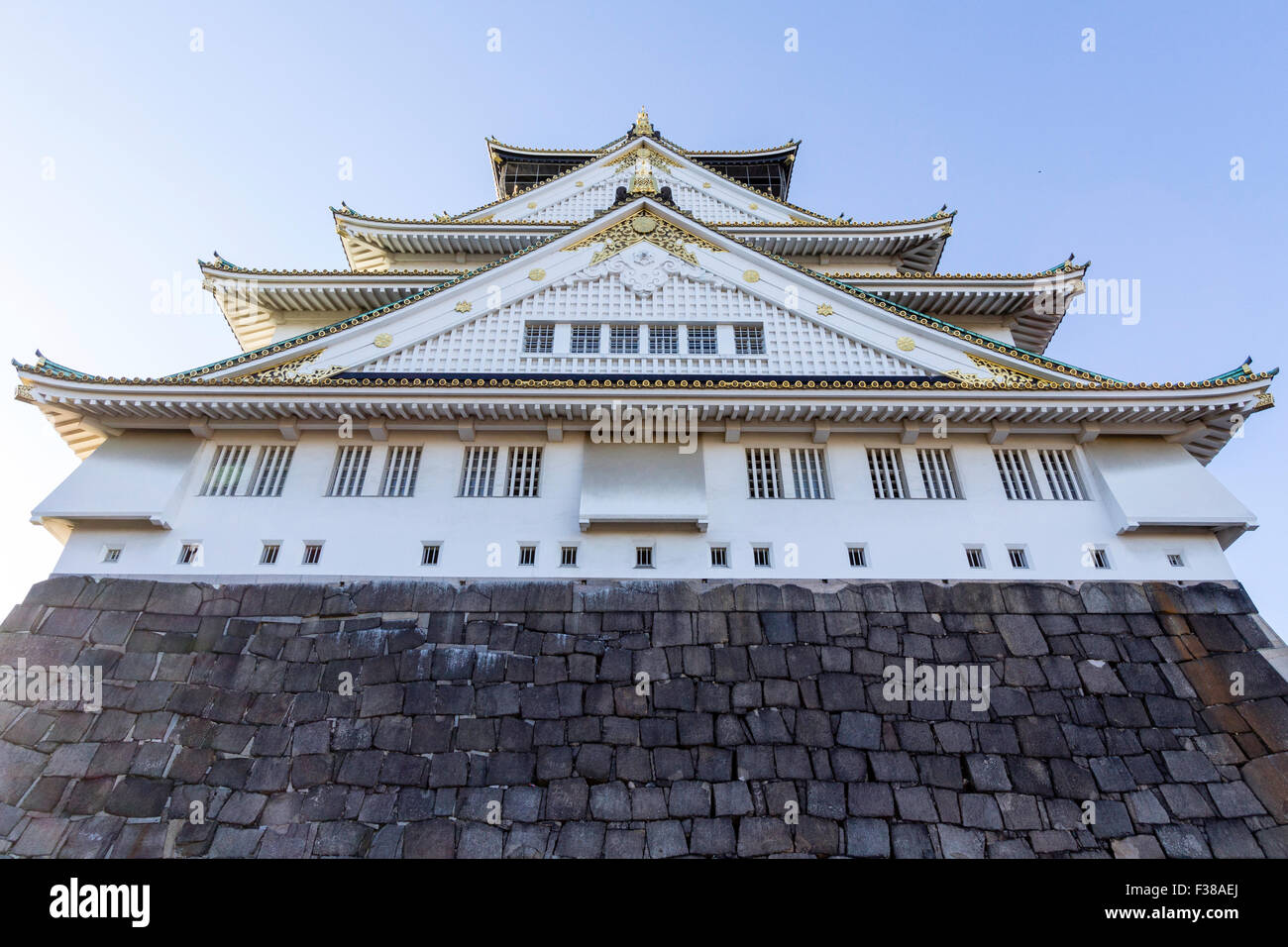 Il Castello di Osaka. Vista dal basamento in pietra del castello di guardare direttamente fino a mantenere la svettante al di sopra del visualizzatore. Soft mattina presto luce. Foto Stock