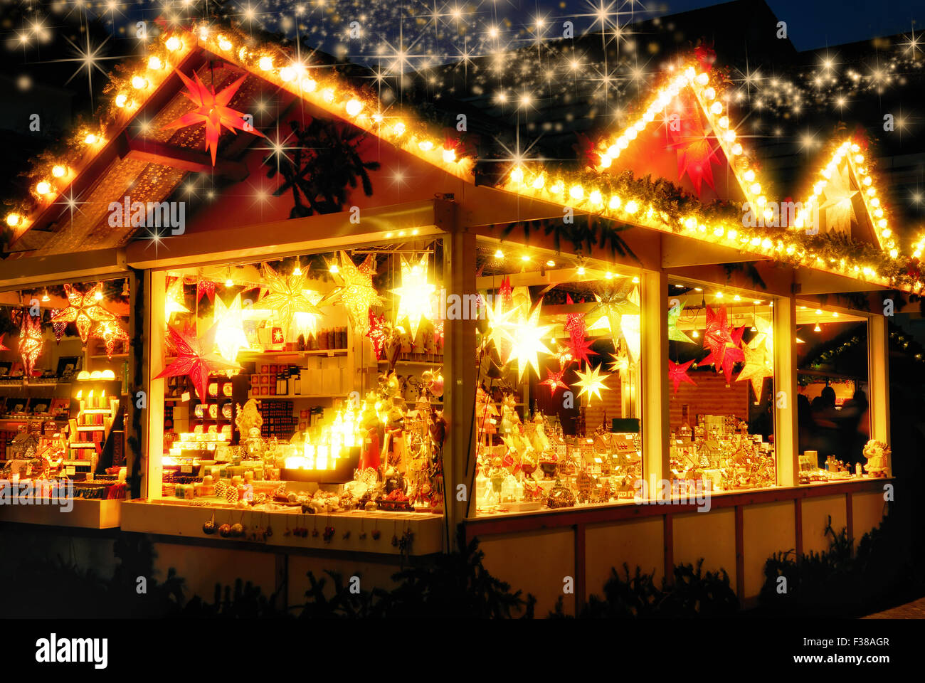 Illuminata fiera di Natale chiosco con carichi di decorazione splendente merchandise, nessun logo, con scintillanti stelle magico di piovere d Foto Stock