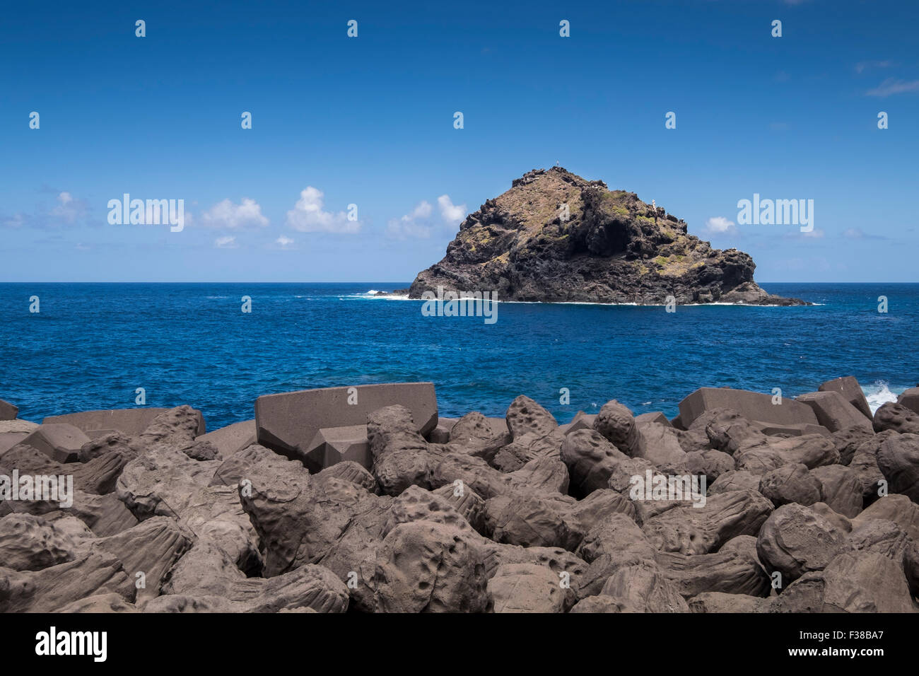 Vista la roccia di Garachico oltre le difese di mare sulla costa nord di Tenerife, Isole Canarie, Spagna. Bianco nero F38B9P Foto Stock