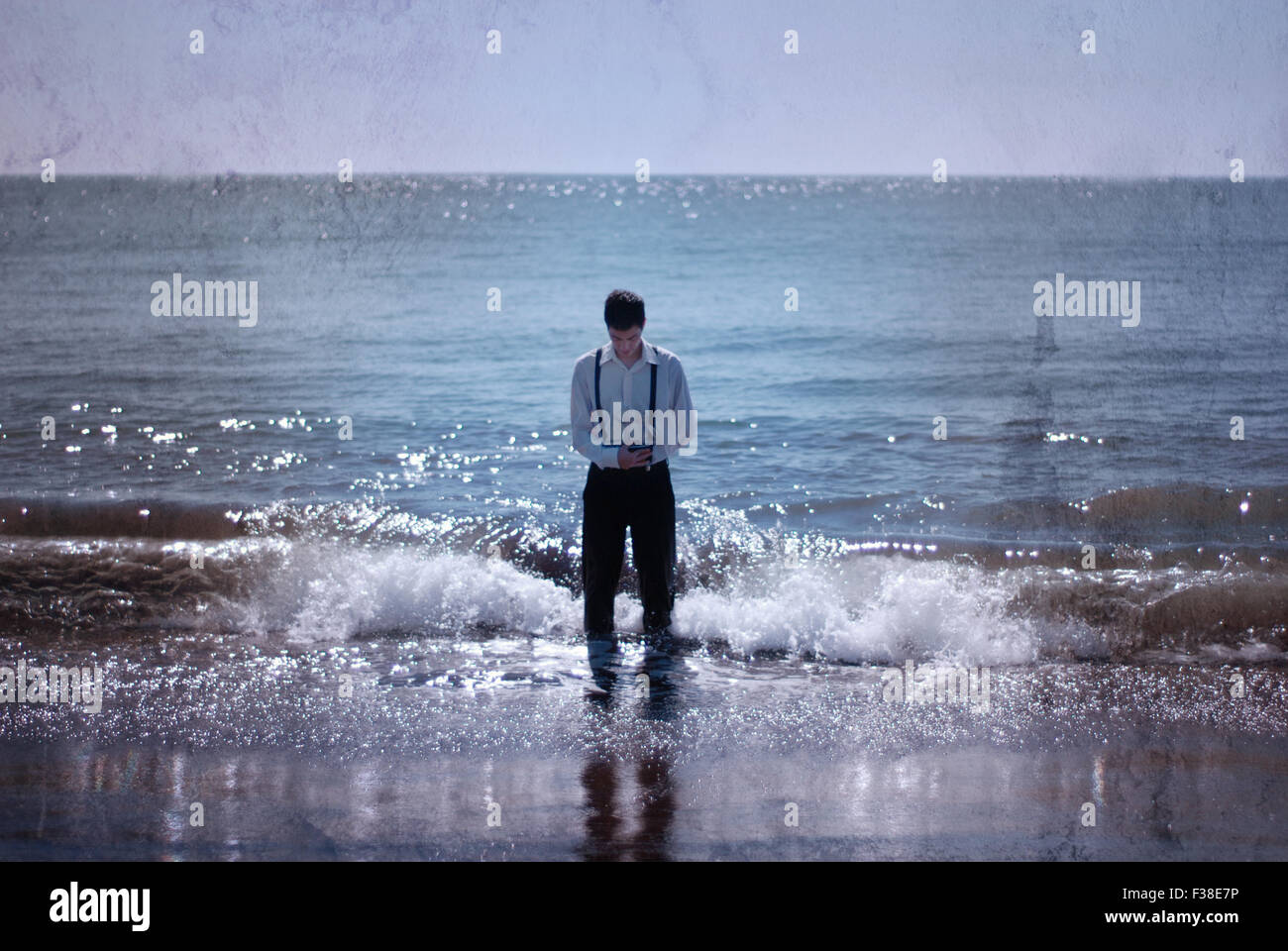 Ragazzo stand up nell'oceano tenendo una texture in barca Foto Stock