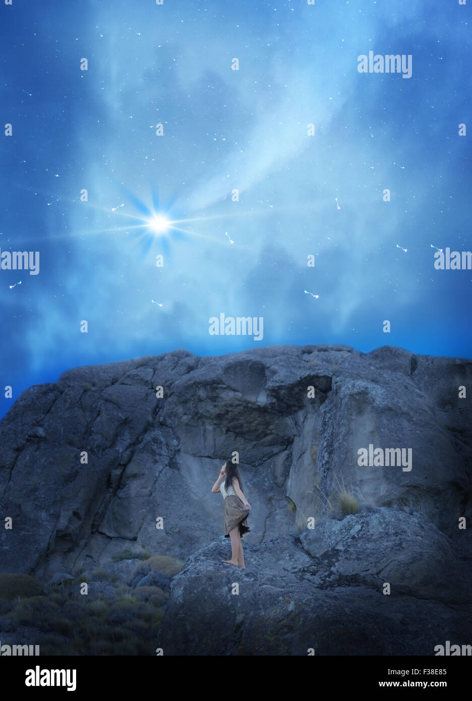 Ragazza in abito di alzarsi in una montagna mentre lei vede il cielo Shooting Star Foto Stock