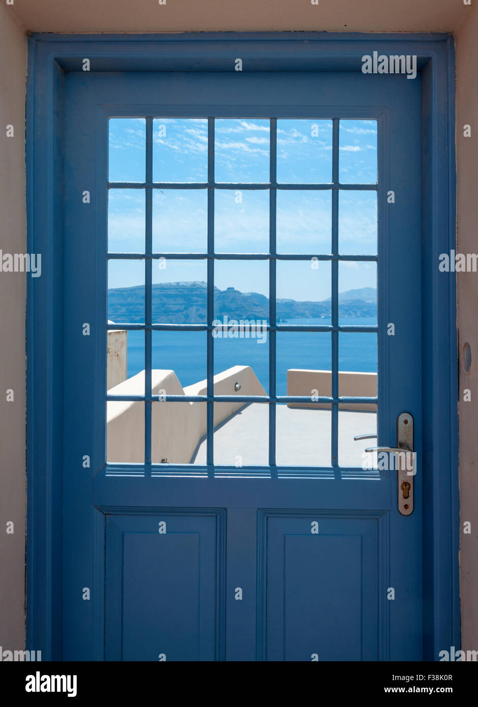 Vista attraverso una porta di ferro in Oia a Santorini con una vista sull'Egeo meridionale in una giornata di sole. Foto Stock