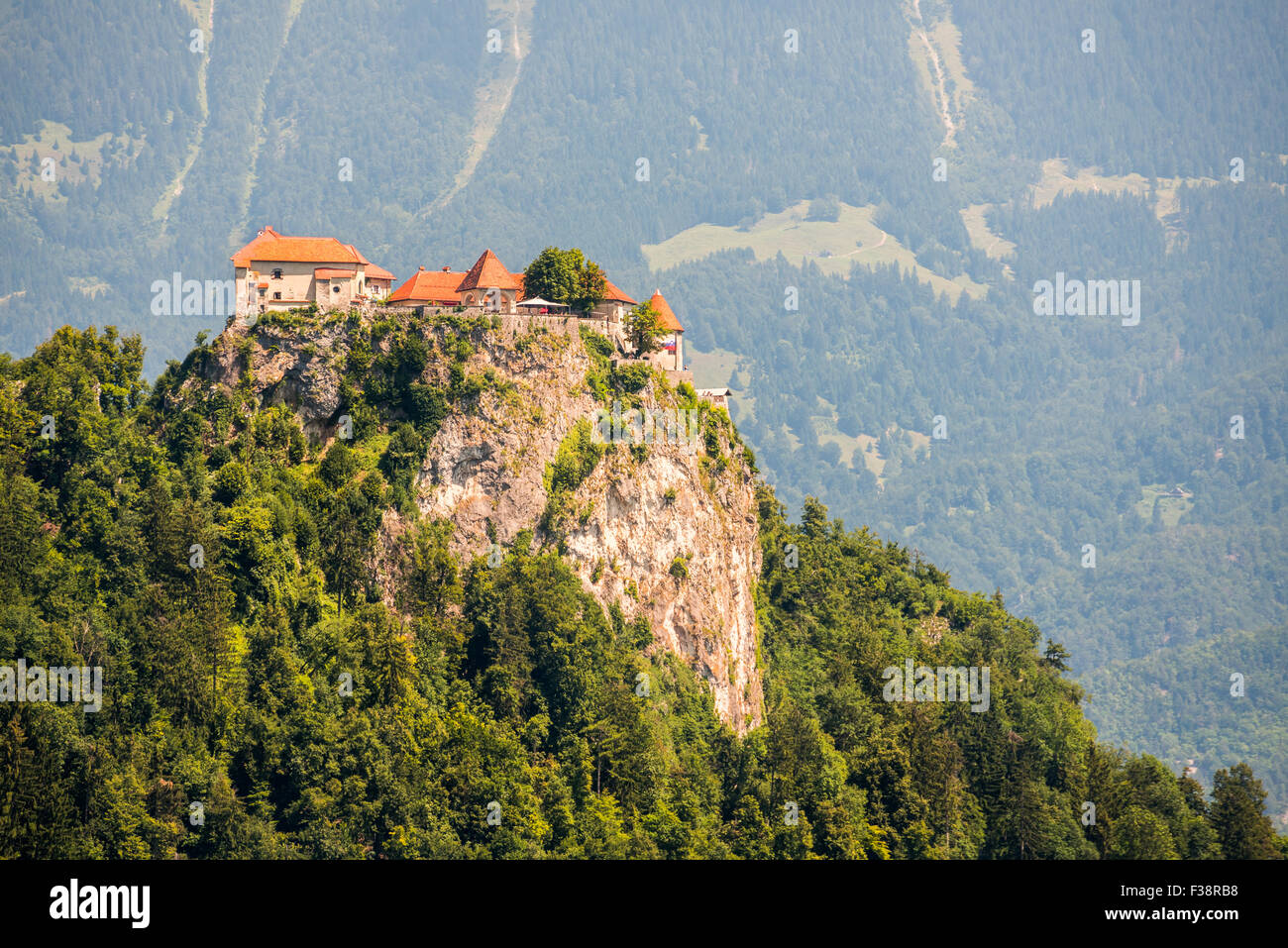 Dettaglio del castello di Bled su una roccia in Slovenia con la montagna in background Foto Stock