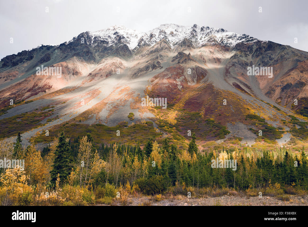 Il sole pigoli attraverso un poco nuvoloso cielo alla luce l'Alaska Range Foto Stock