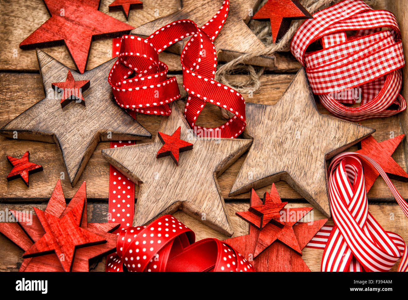 Le decorazioni di Natale stelle di legno e nastri di colore rosso. Nostalgica in stile retrò tonica foto Foto Stock