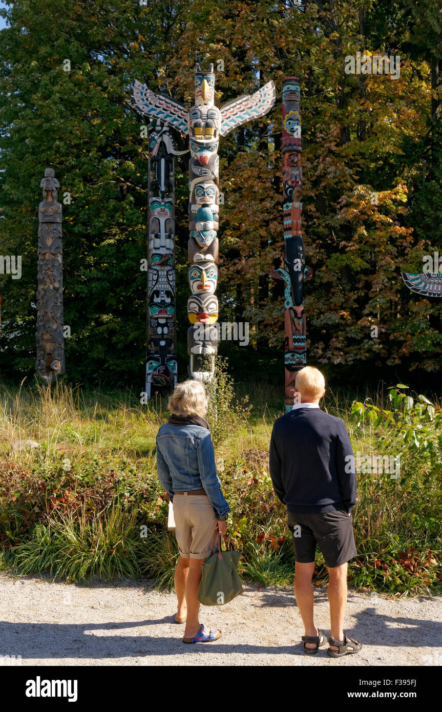 Donna anziana e un uomo guarda il totem a Brockton Point in Stanley Park, Vancouver, British Columbia, Canada Foto Stock