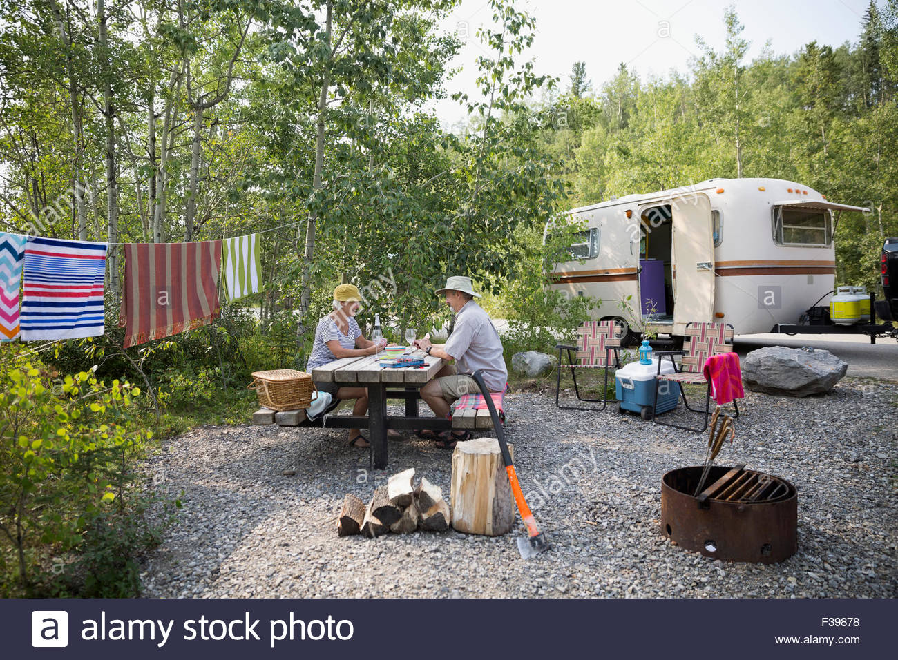Coppia senior campeggio tavolo da picnic al di fuori del camper rimorchio Foto Stock