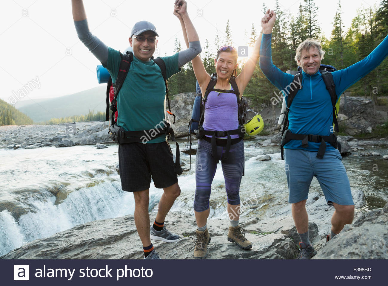 Ritratto entusiasta Escursionisti con le braccia sollevate in fiume Foto Stock