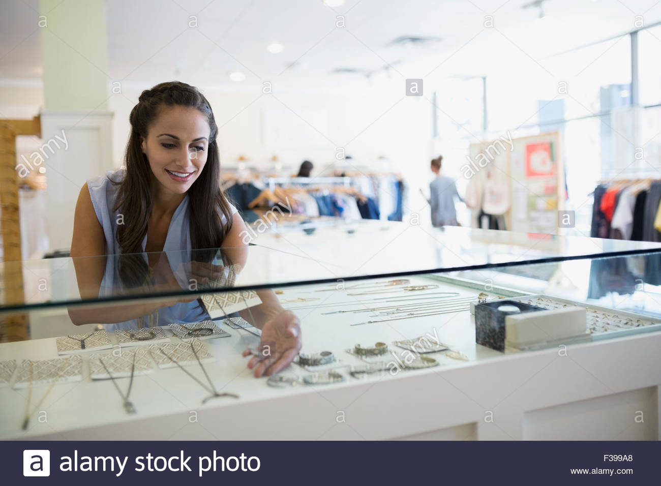 Lavoratore disponendo gioielli espositore in negozio Foto Stock