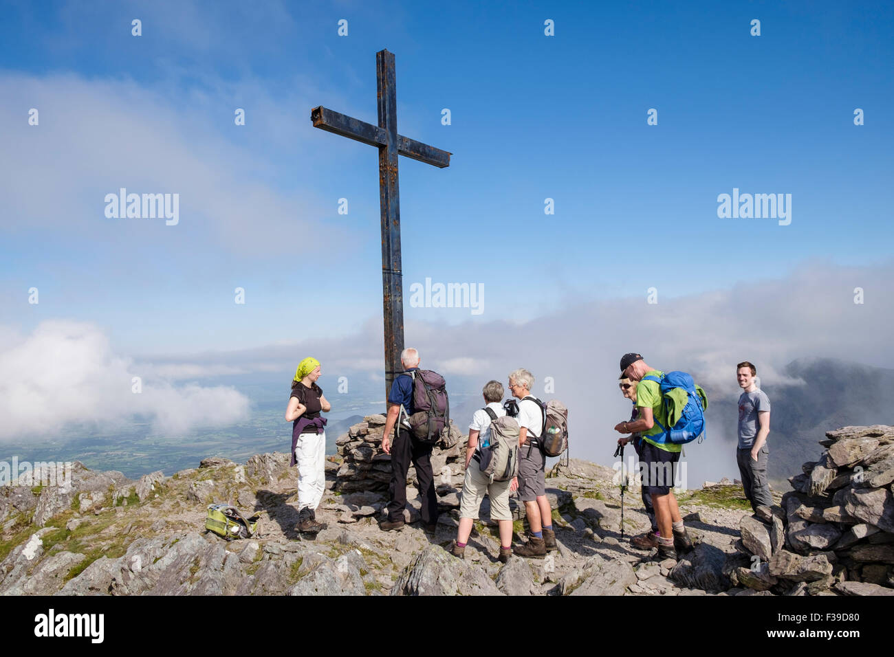 Gli escursionisti dal ferro crocifisso croce sul monte Carrauntoohil vertice di MacGillycuddy Reeks, nella contea di Kerry, Eire, sud Irlanda Foto Stock