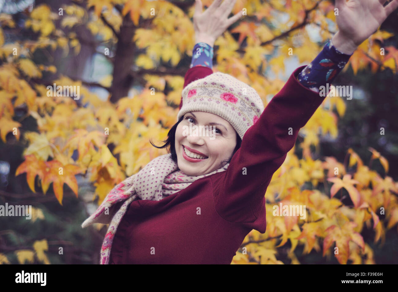 Felice metà donna adulta con bracci sollevati autunno Foto Stock