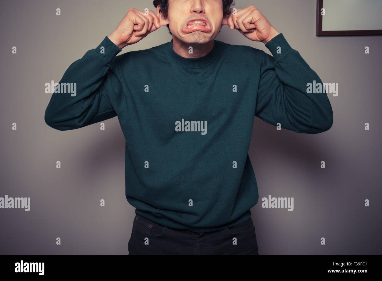 Un giovane uomo è gesticolando e tirando le facce stupide Foto Stock