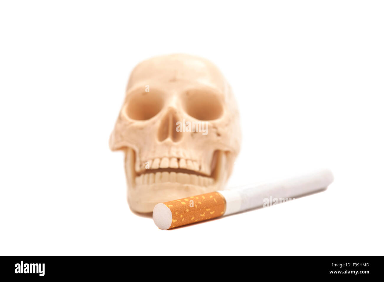 Scull umana con la sigaretta isolato su bianco Foto Stock