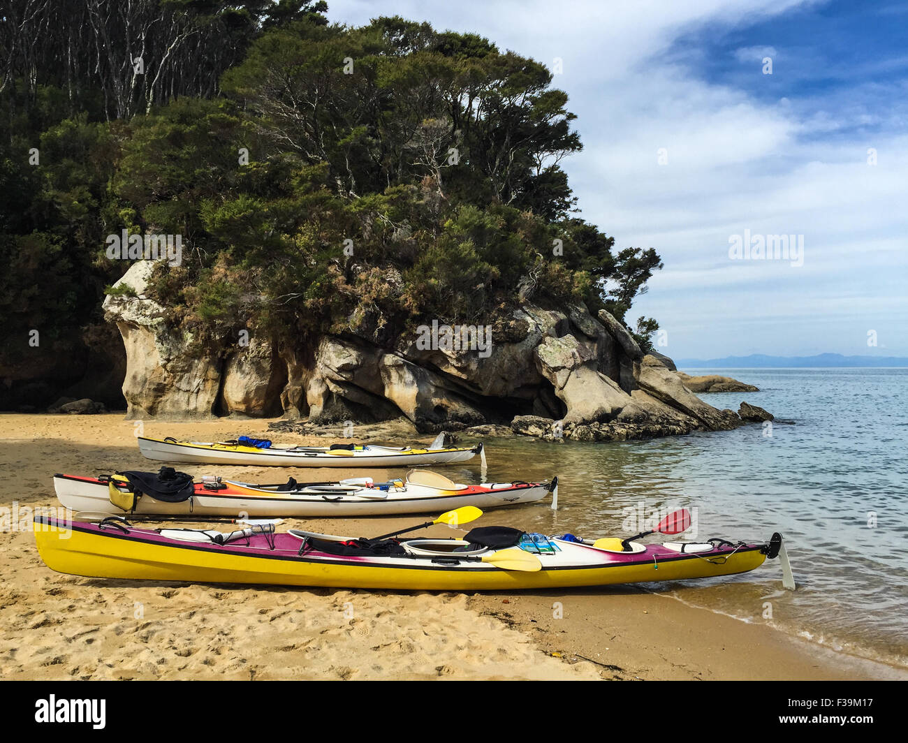 Tre kayak da mare sulla spiaggia di Baia di irrigazione, il Parco Nazionale Abel Tasman, Nuova Zelanda Foto Stock