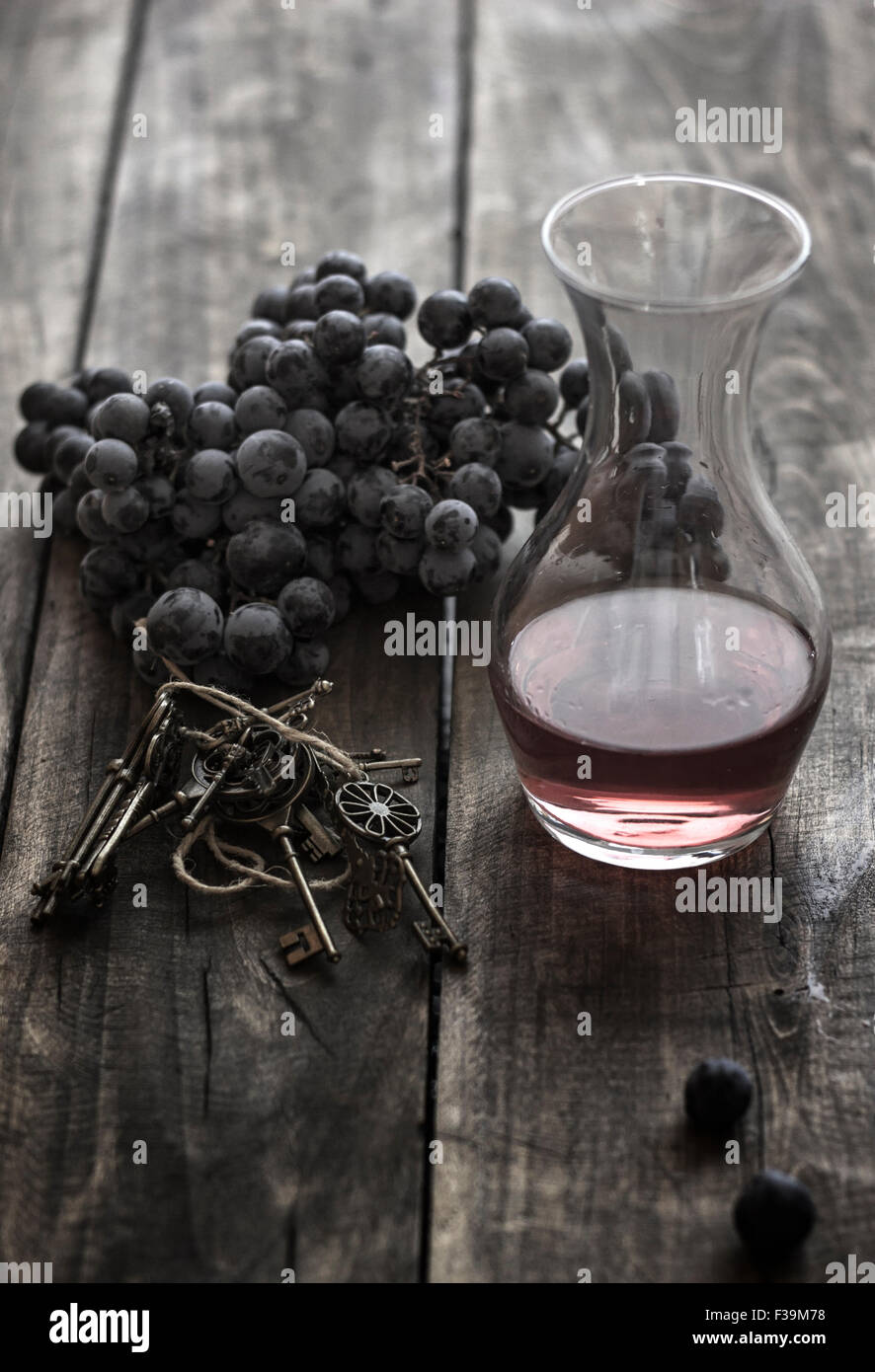 Bottiglia di vino rosso Uva snd sul rustico sfondo di legno Foto Stock