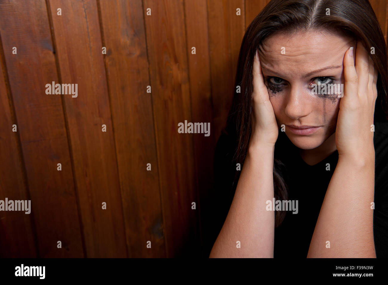 Lacrimoso giovane donna, con la testa con le mani. Foto Stock