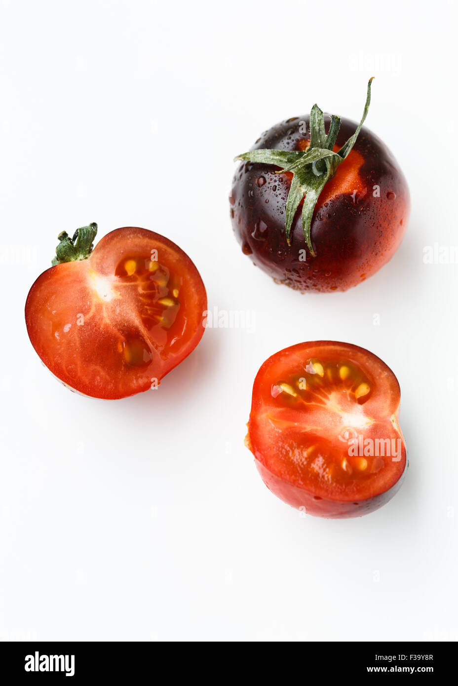 Nero pomodori ciliegia su sfondo bianco Foto Stock