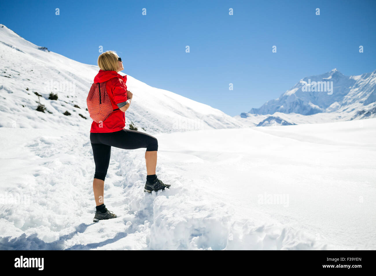 Giovane donna felice escursionista guardando a picchi di montagna in inverno le montagne. Escursioni e viaggi ispirazione e motivazione, bella l Foto Stock