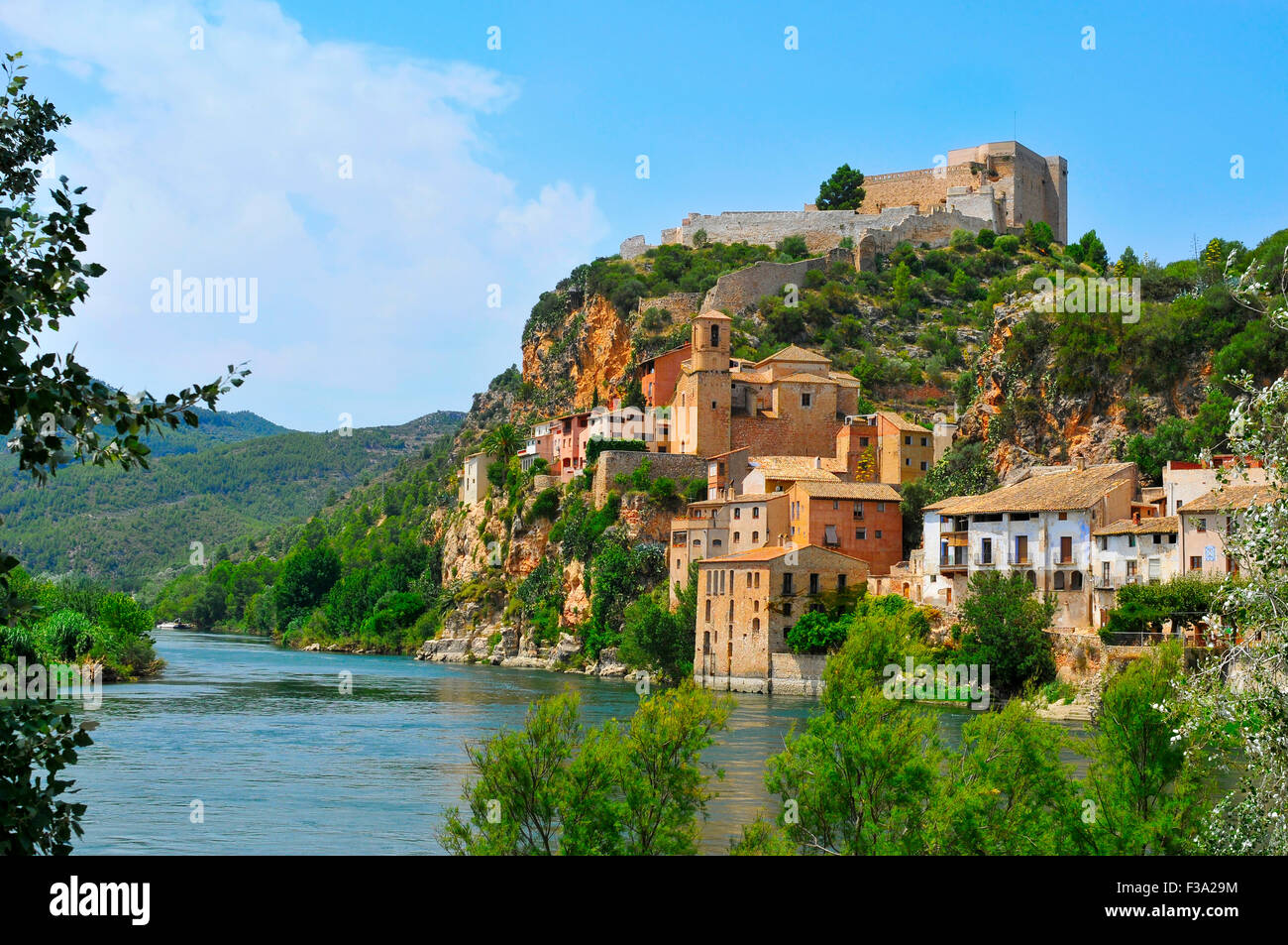 Vista del fiume Ebro e la città vecchia di Miravet, Spagna, evidenziando il castello dei templari nella parte superiore della collina Foto Stock