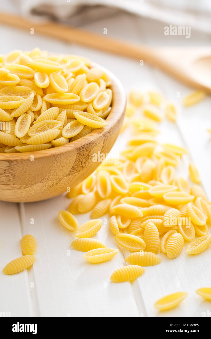 Non cotti pasta italiana nella ciotola di legno sul tavolo da cucina Foto Stock