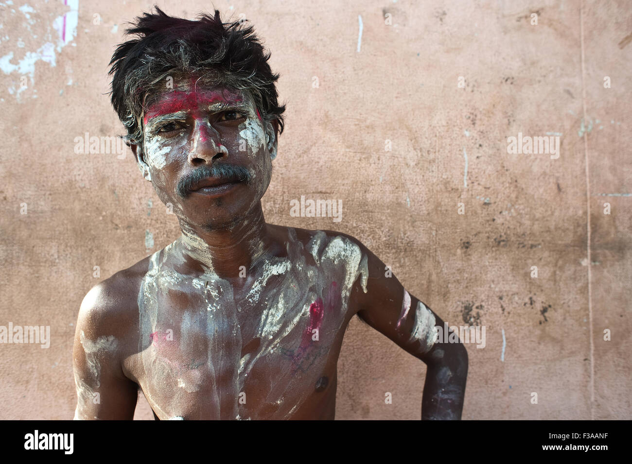 Uomo di accattonaggio con il viso e corpo verniciato in rosso e bianco ( India) Foto Stock