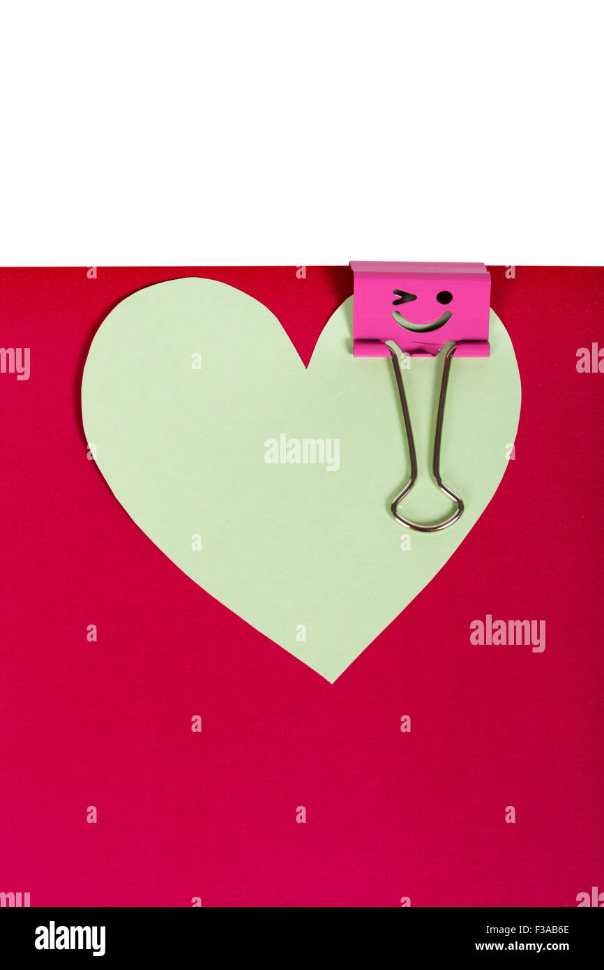 Cuore di carta appuntato legante rosa con smiley su sfondo bianco Foto Stock
