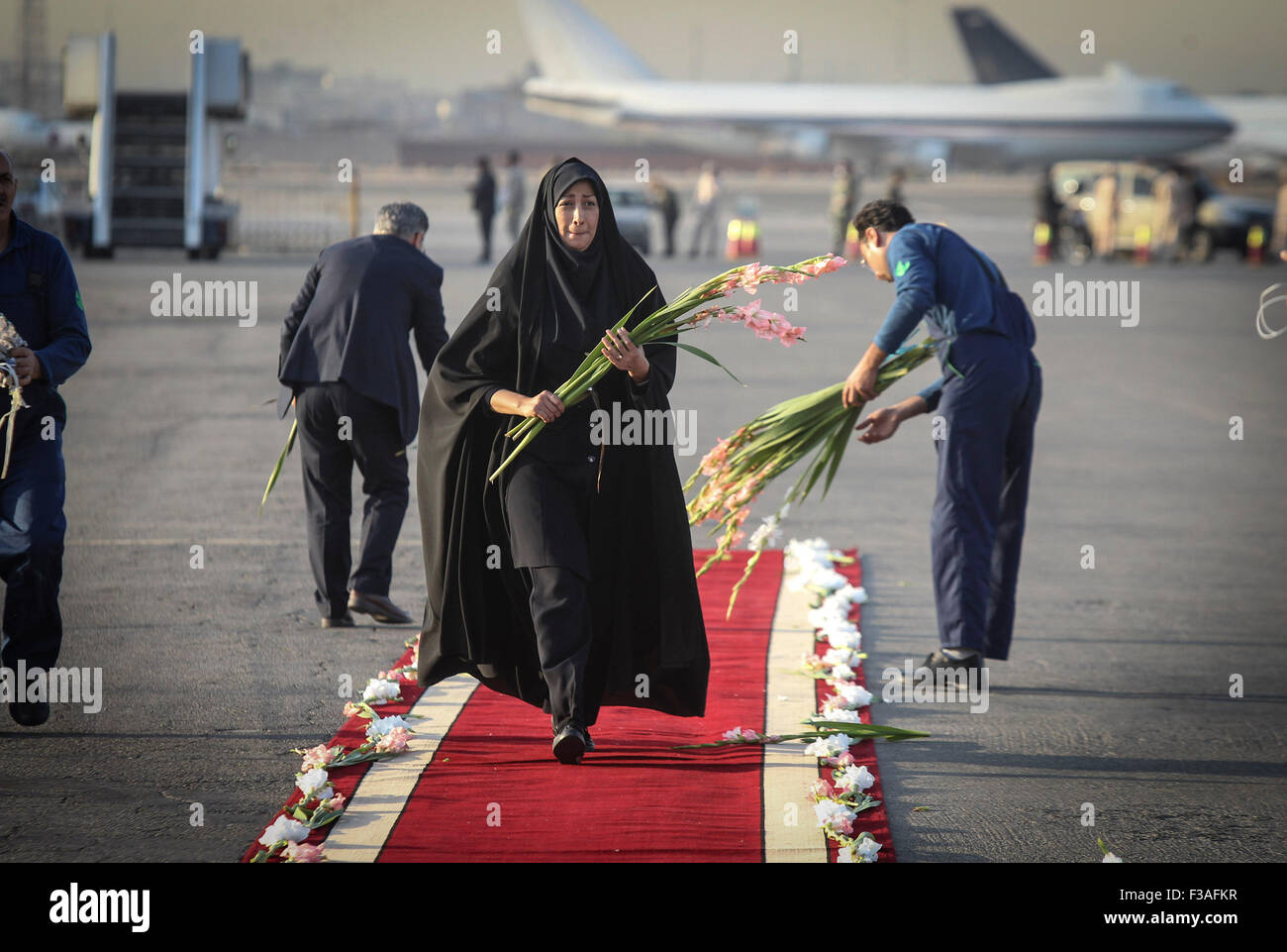 Tehran, Iran. 3° Ott, 2015. Una donna iraniana organizza fiori prima di una cerimonia per rendere omaggio a 104 pellegrini iraniani uccisi negli ultimi Hajj stampede e trasferito al aeroporto di Mehrabad a Teheran, capitale dell'Iran, il Ott 3, 2015. Rouhani sabato spinto per un'indagine sulle ultime Hajj stampede in Arabia Saudita che ha lasciato 465 pellegrini iraniani morti. Credito: Ahmad Halabisaz/Xinhua/Alamy Live News Foto Stock