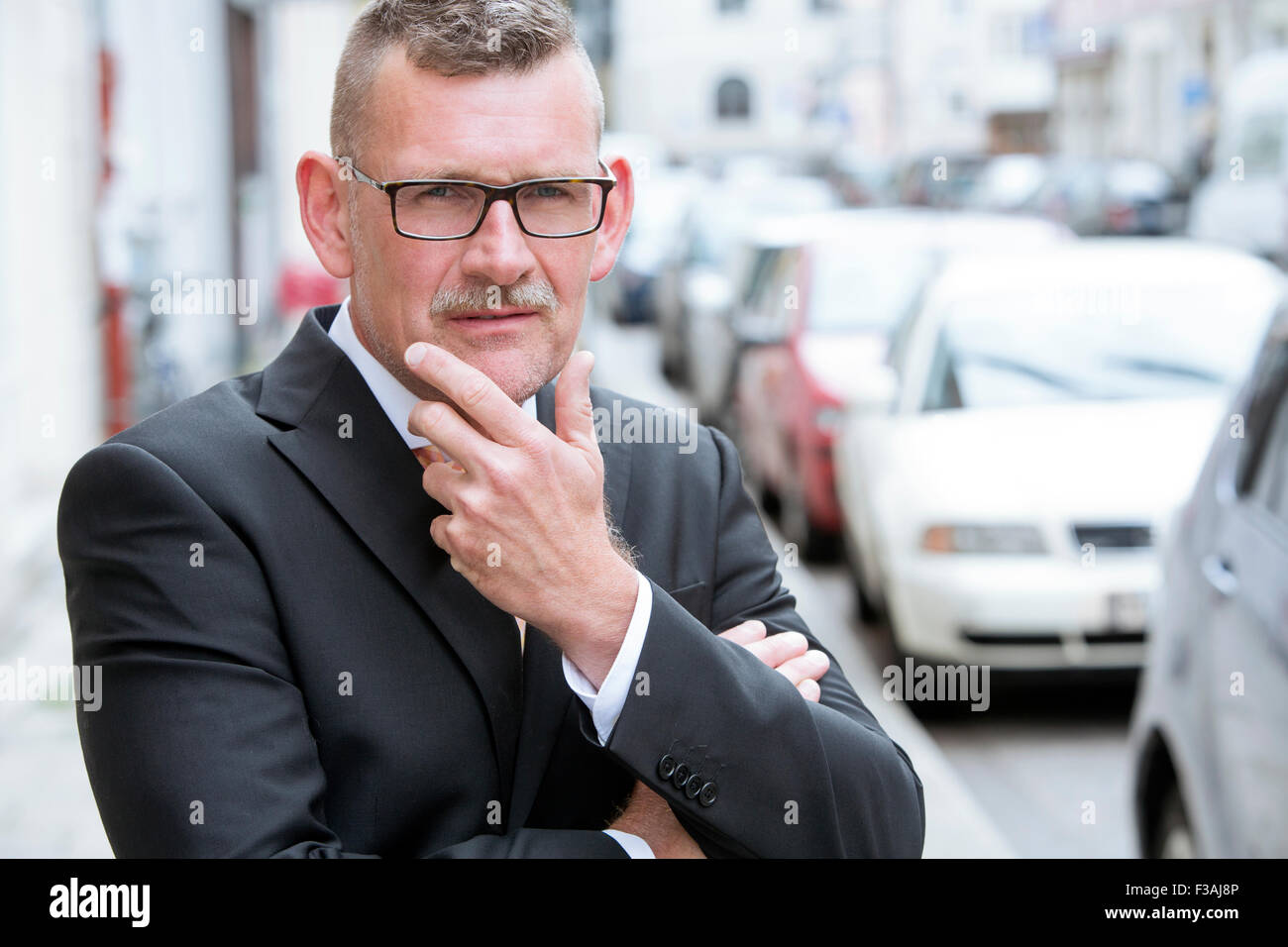 Ritratto di imprenditore con bicchieri in piedi in strada Foto Stock