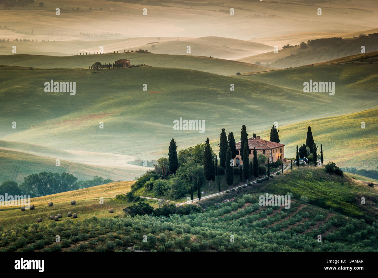 Toscana, Val d'Orcia, incredibile paesaggio con colline, cipressi e olivi, Italia. Agriturismo solitario nel paesaggio rurale Foto Stock