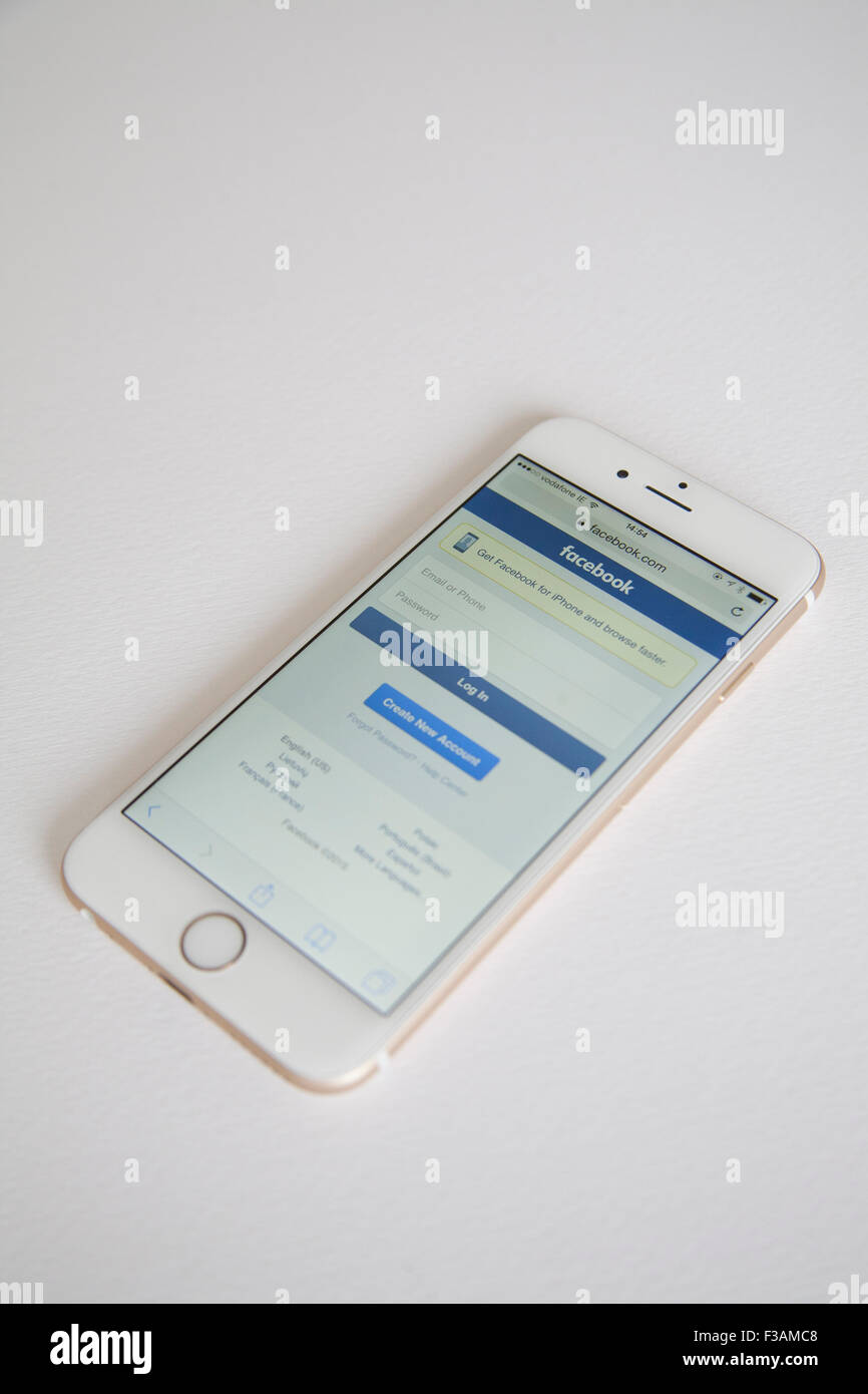 Oro e Bianco Apple iPhone 6 con Facebook log in pagina contro uno sfondo bianco Foto Stock