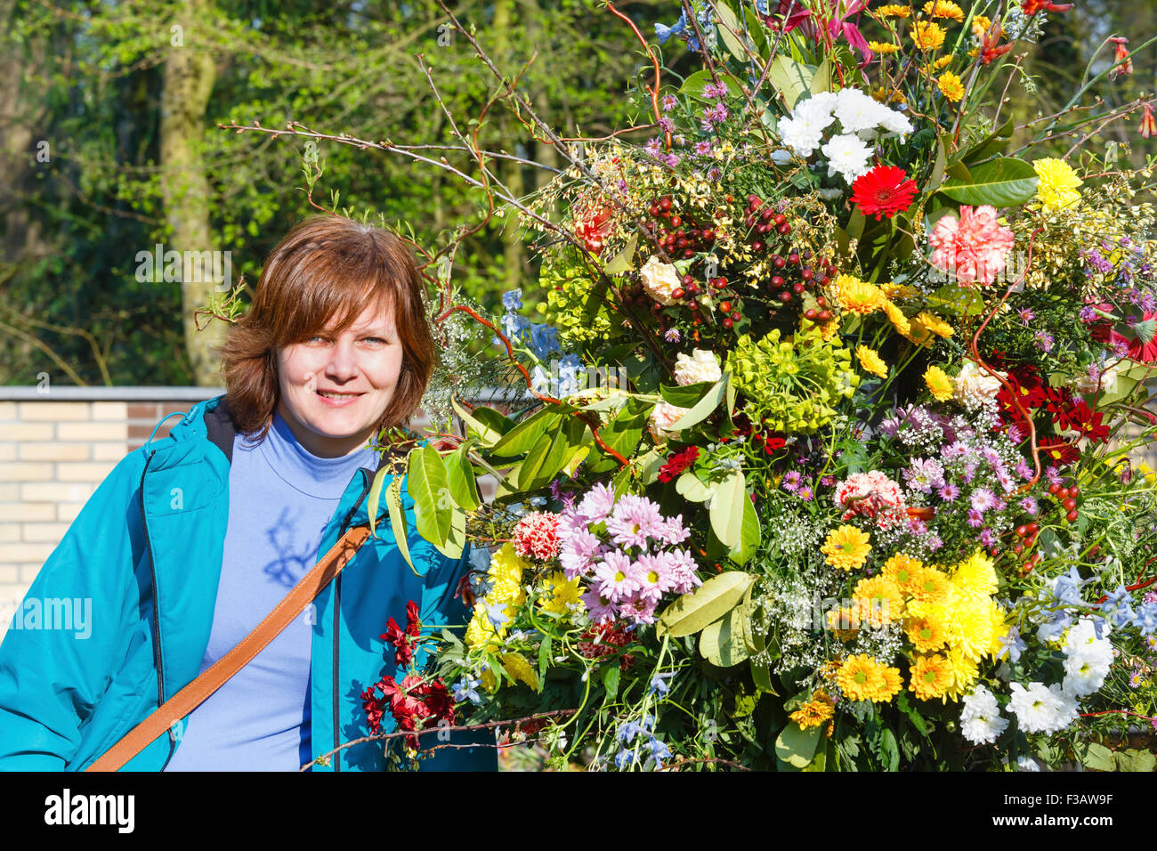 Donna vicino al grande variegato bouquet di primavera nel parco. Foto Stock