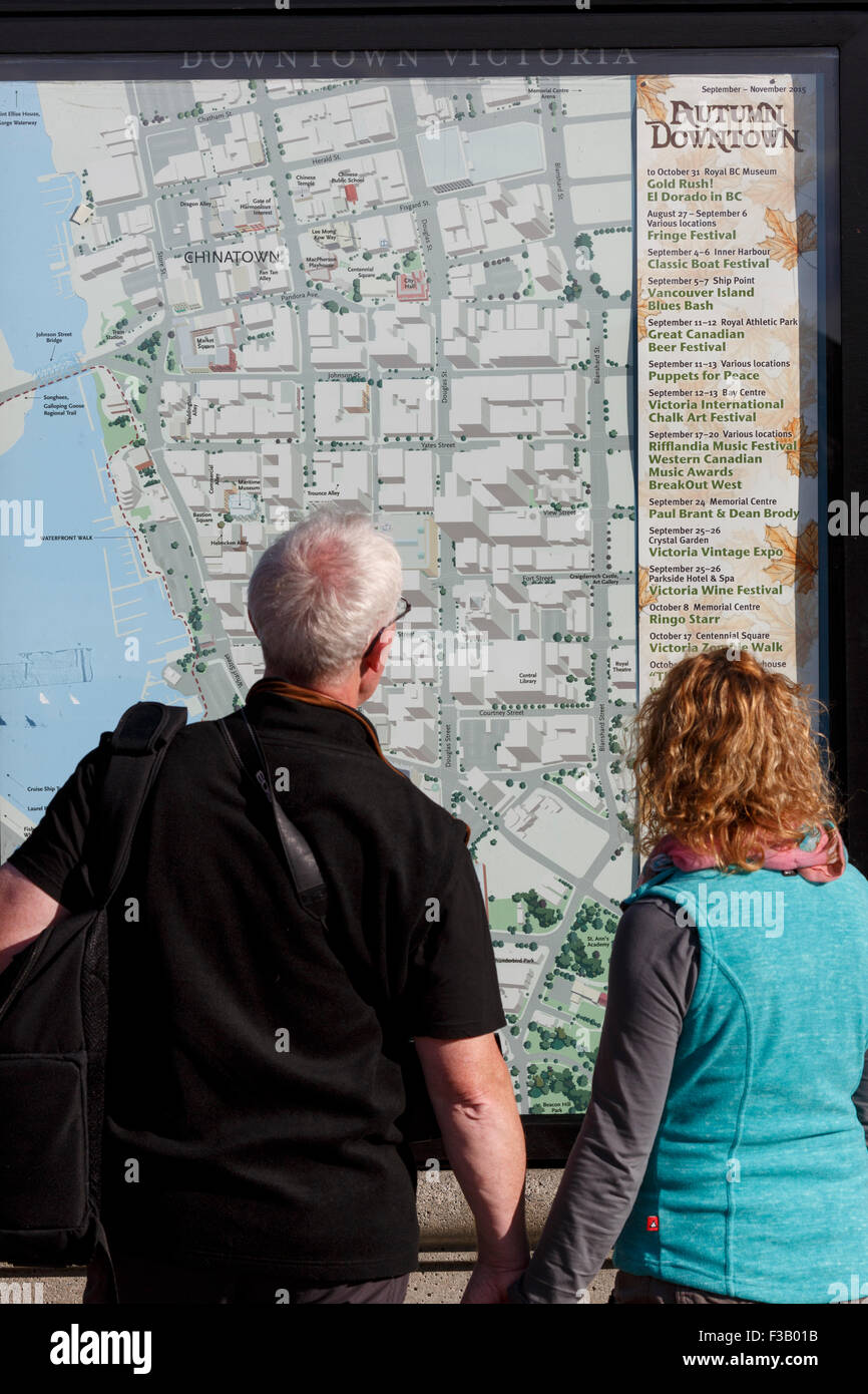 Giovane studiare mappa downtown Victoria mappa pubblica British Columbia Foto Stock