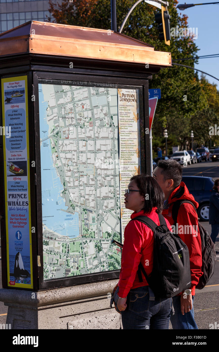 Giovane studiare mappa downtown Victoria mappa pubblica British Columbia Foto Stock