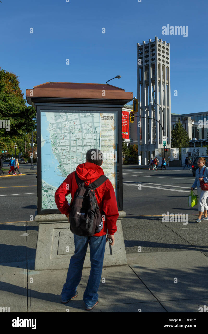 L'uomo studiare Informazioni turistiche Mappa downtown Victoria mappa pubblica British Columbia Foto Stock