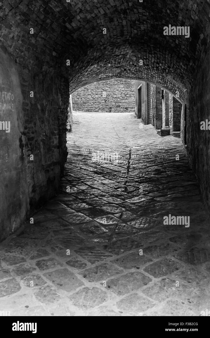 Stretta viuzza acciottolata, Volterra, Toscana, Italia Foto Stock