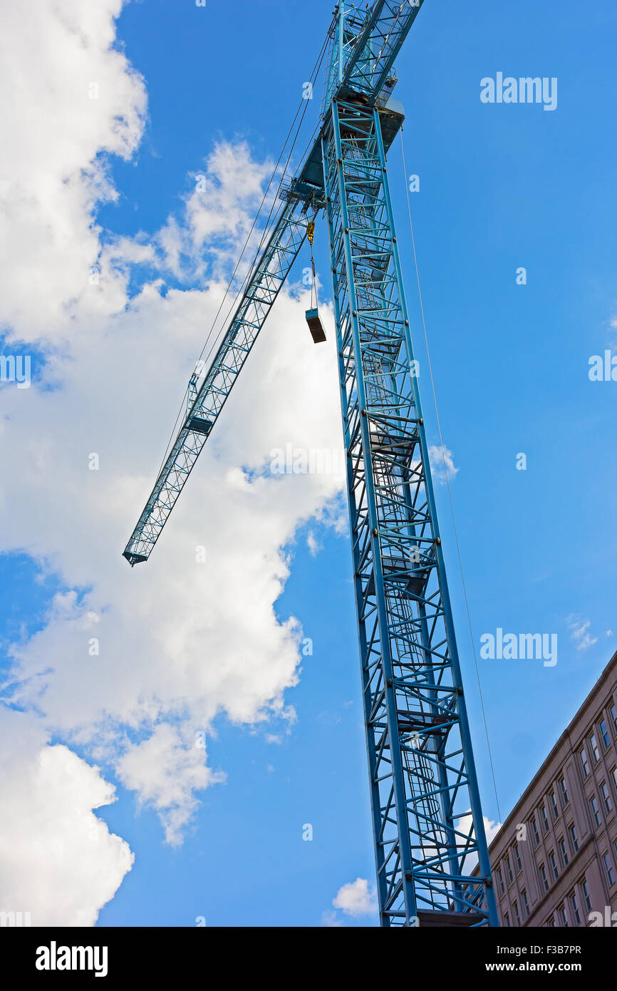 Blue gru da cantiere contro un nuvoloso cielo blu. Foto Stock