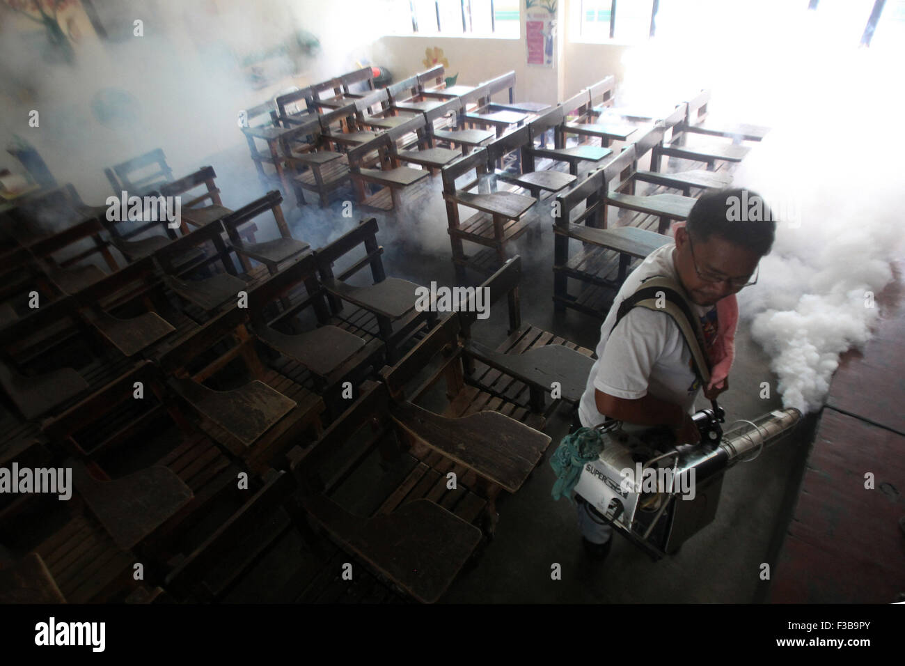 Paranaque City, Filippine. 4 Ott 2015. Un lavoratore fumigates una scuola per prevenire la diffusione della malattia di dengue in Paranaque City, Filippine, Ottobre 4, 2015. Il Dipartimento della Salute (DOH) ha registrato un totale di 78,808 casi di dengue da Gen 1 a sett. 5 questo anno, un 16,5 percento di aumento rispetto allo stesso periodo dello scorso anno. © Rouelle Umali/Xinhua/Alamy Live News Foto Stock